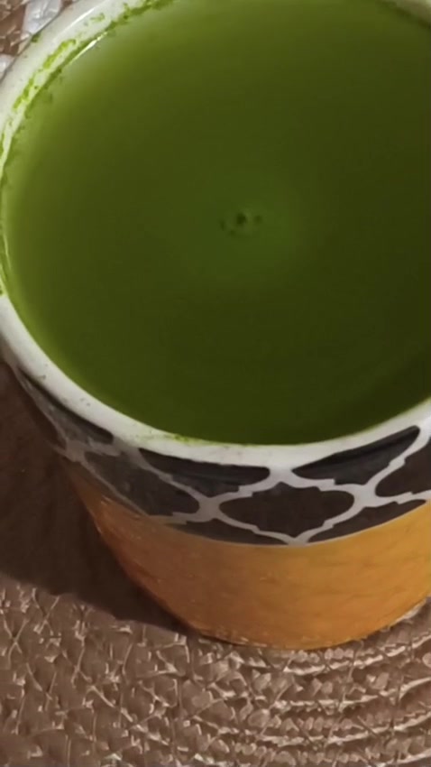 A cup of bright green moringa drink